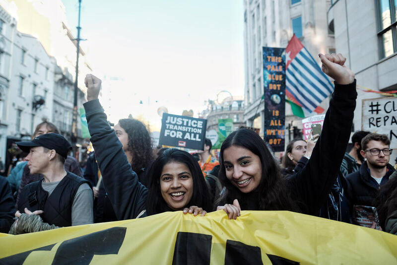 To kvinder holder et banner til en klimamarch.